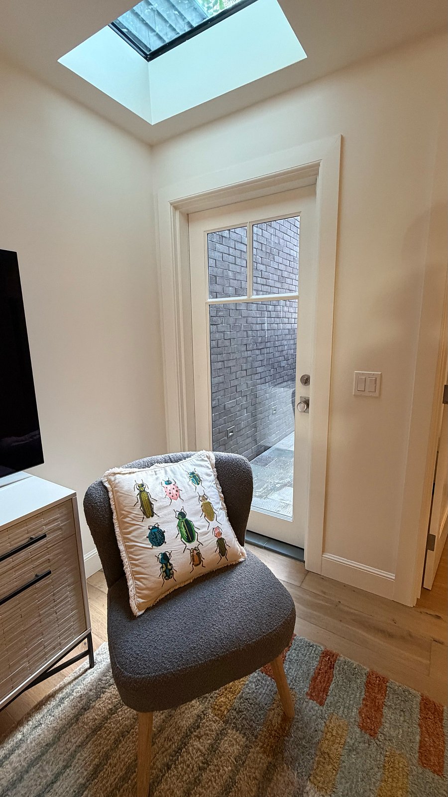 Living room corner showing skylight and glass back door to small private patio (stairs to shared garden)