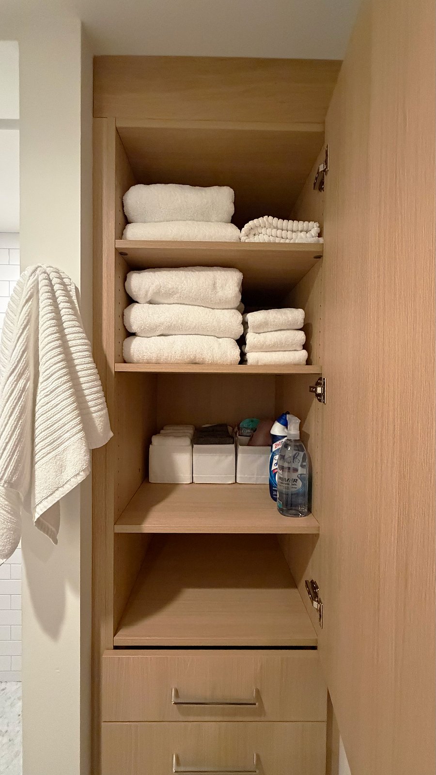 Bathroom wall cabinetry with plenty of fluffy new towels, new hair dryer and starter amenities