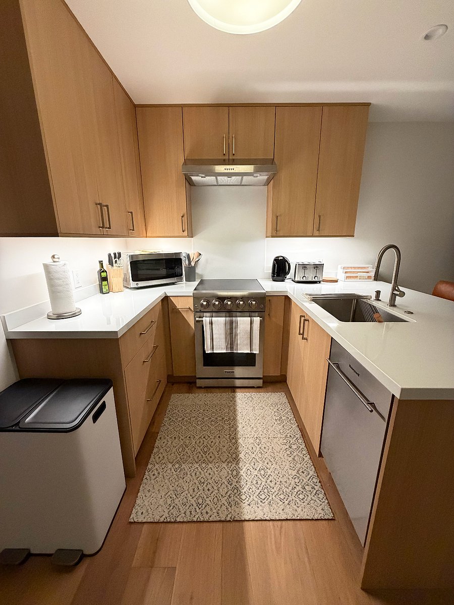 Fully appointed kitchen showing all new range, dishwasher, microwave, kettle, toaster, trash/recycling/compost bins (coffee maker & blender not shown)