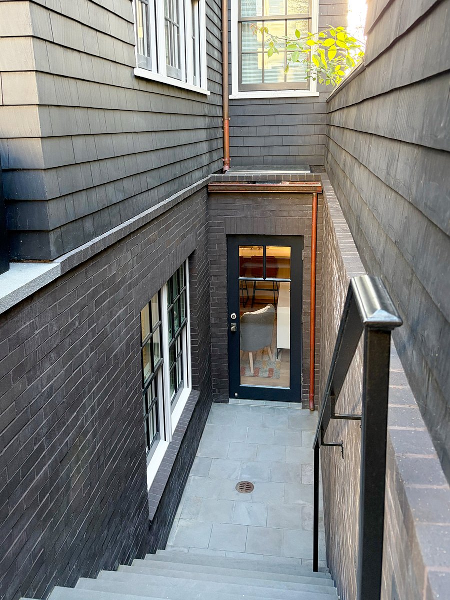 Rear sunken patio (private) showing back door, bedroom windows & skylight. Door has hook to keep open for fresh air (apartment also has A/C)
