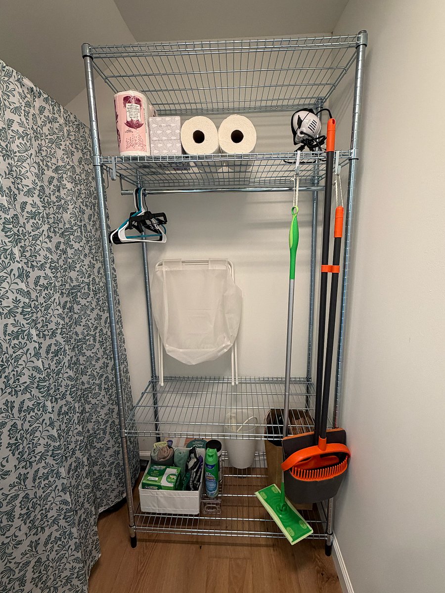 (1st of 2 pics) Front storage closet with clothing/shelf rack, cleaners, vacuum, and spare household items