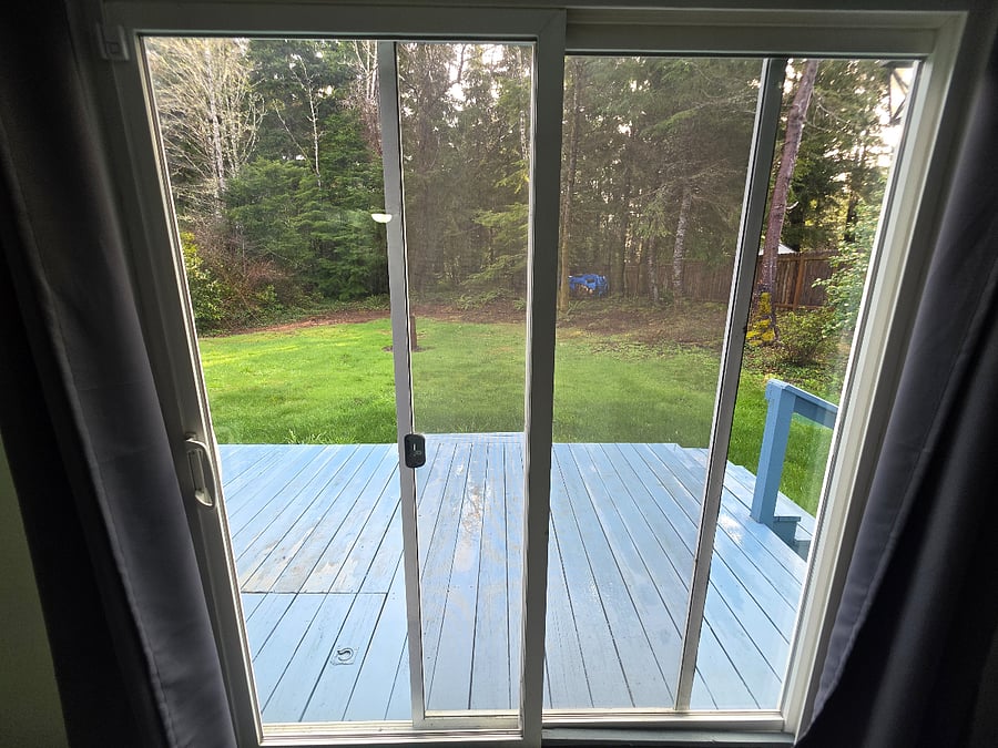 View from inside looking out to the private back yard and deck