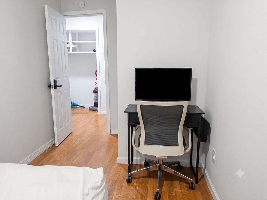Bedroom includes a dedicated desk workspace with TV and laminate flooring, plus easy access to the hallway.
