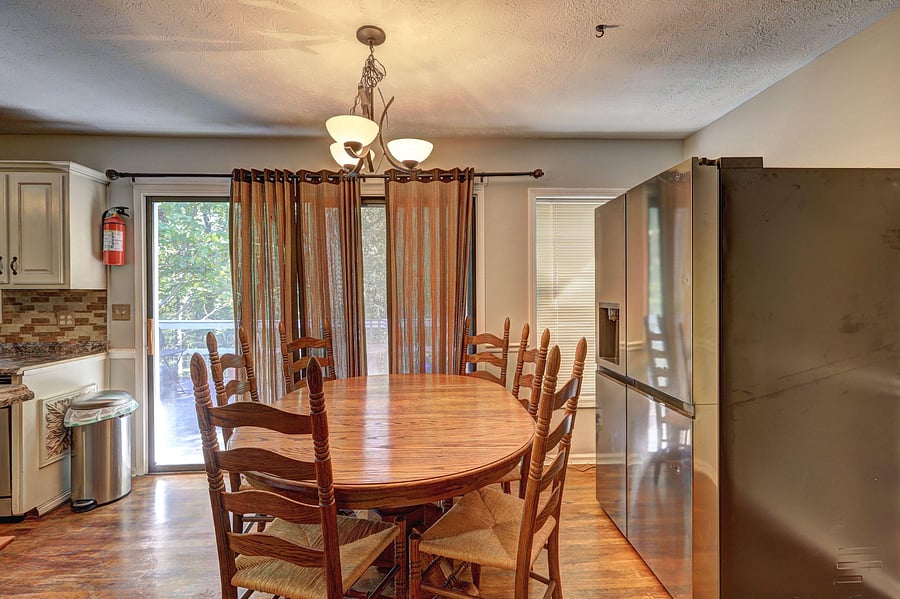 Eat-in dining area with a full table and seating, pendant lighting, and sliding-door access for easy indoor-outdoor flow.