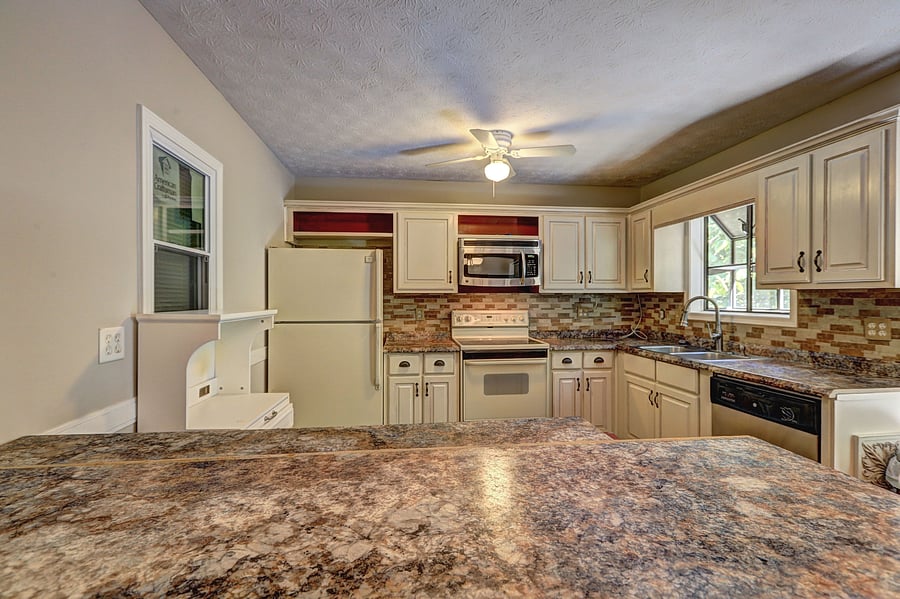 Spacious kitchen with ample cabinet storage, granite-look counters, and a full appliance suite plus windowed sink area.