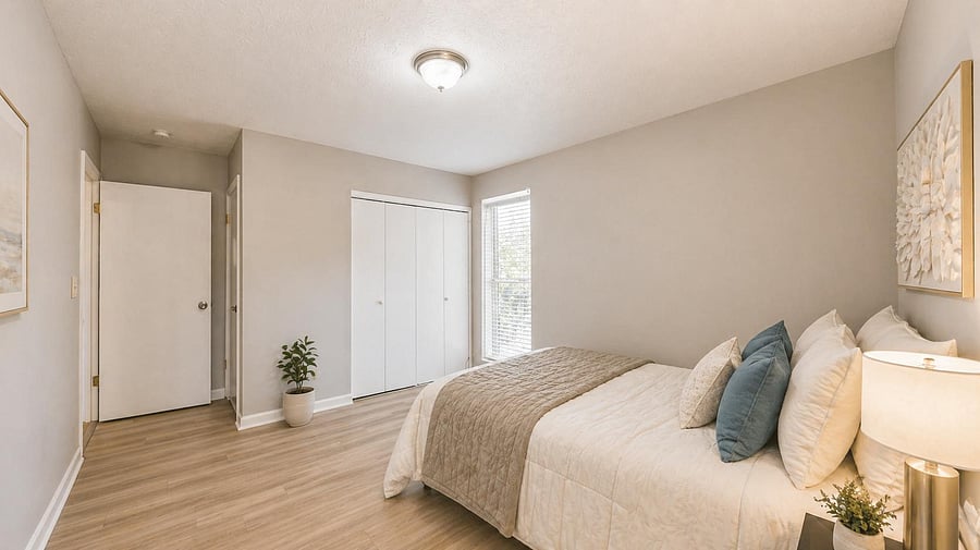 Spacious bedroom with wood-look floors, a wide closet, and a window with blinds for natural light and privacy.