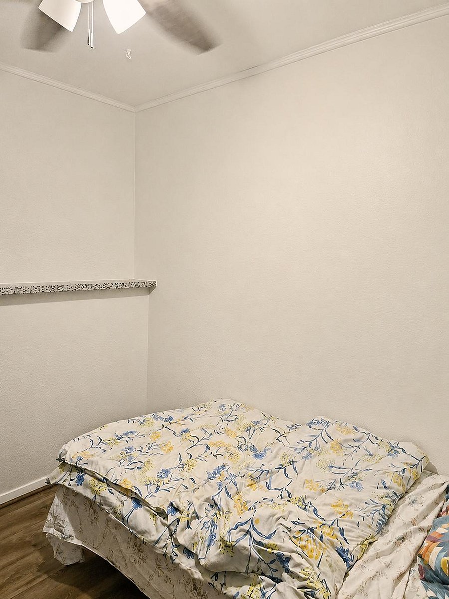 Compact bedroom with a ceiling fan and a built-in ledge that works well for display or bedside essentials.