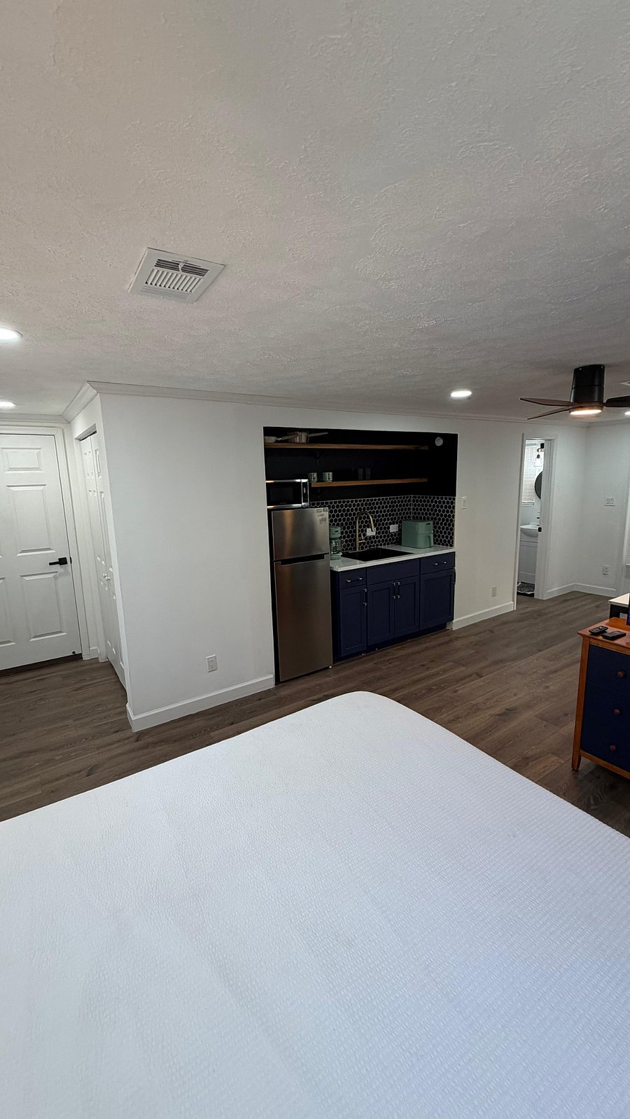 View from the bed.  You can see the half kitchen and bathroom. 