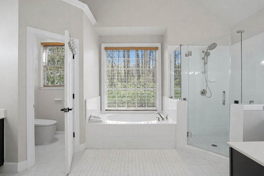 Ensuite primary bathroom with modern finishes and a spa-like soaking tub and shower.