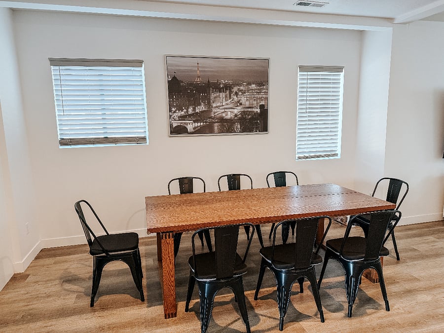 Dining Room with Seating for 8
Large wooden dining table with six stylish black metal chairs and a striking cityscape artwork on the wall.