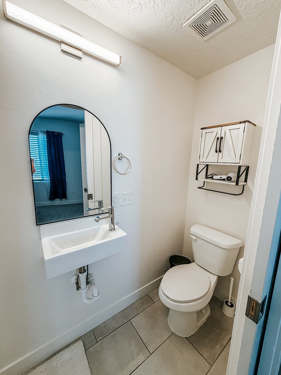 Primary Master Bedroom with Full Bathroom

Spacious first-floor master bedroom featuring a comfortable king bed with green bedding, large window with blackout curtains for better sleep, wall-mounted TV, and direct access to a private full bathroom.