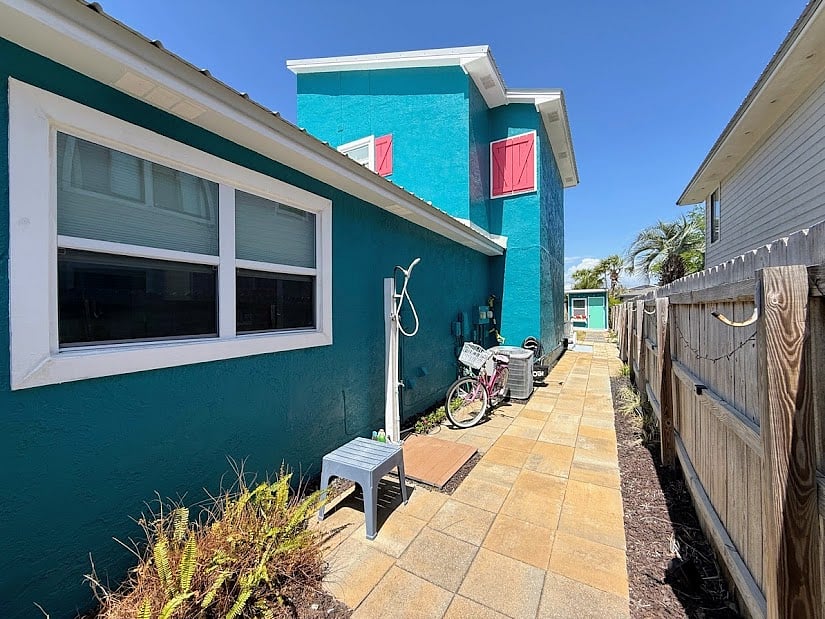 Gated side of house with outdoor shower and bike parking
