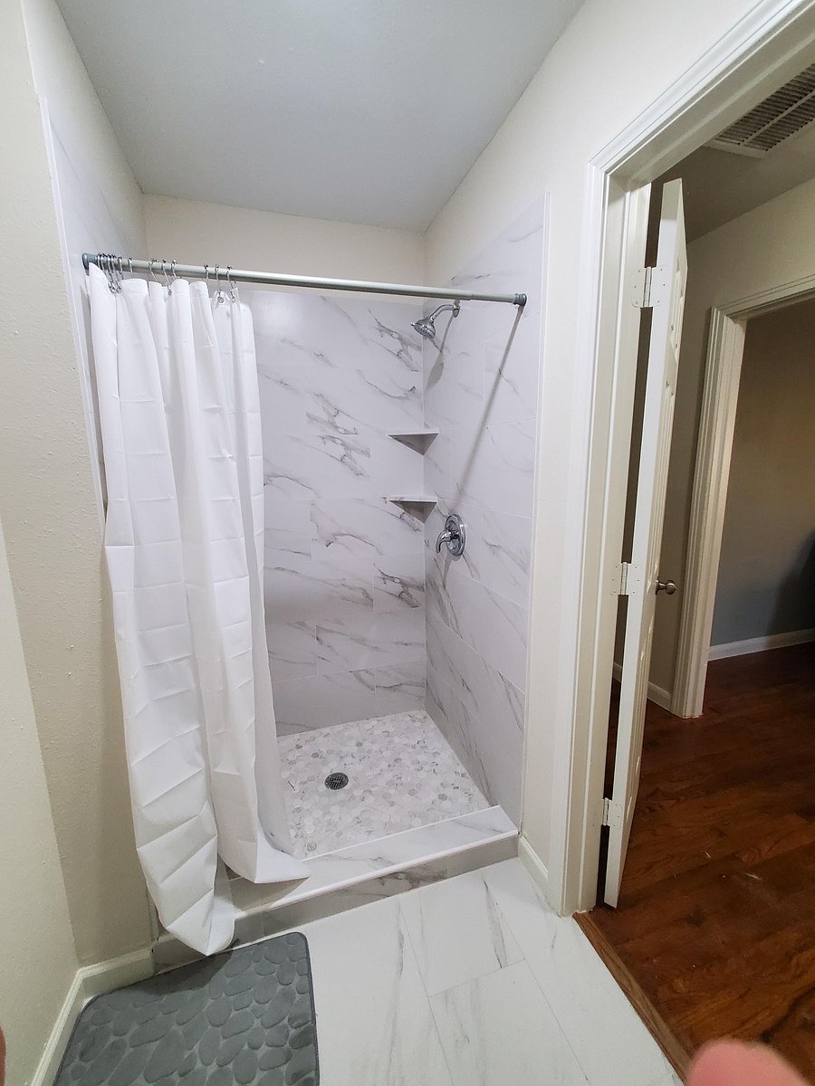 Modern full bathroom featuring a sleek vanity and updated flooring