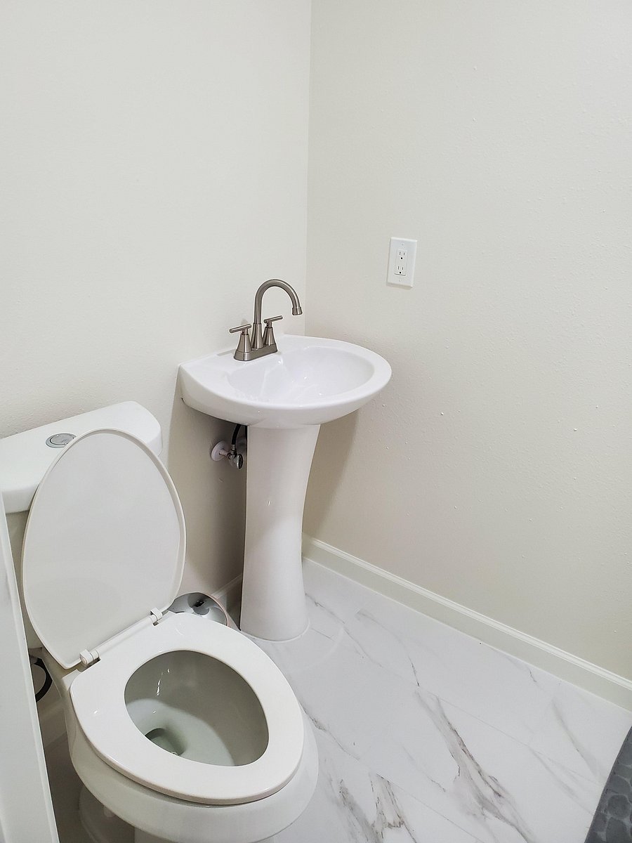 Modern full bathroom featuring a sleek vanity and updated flooring