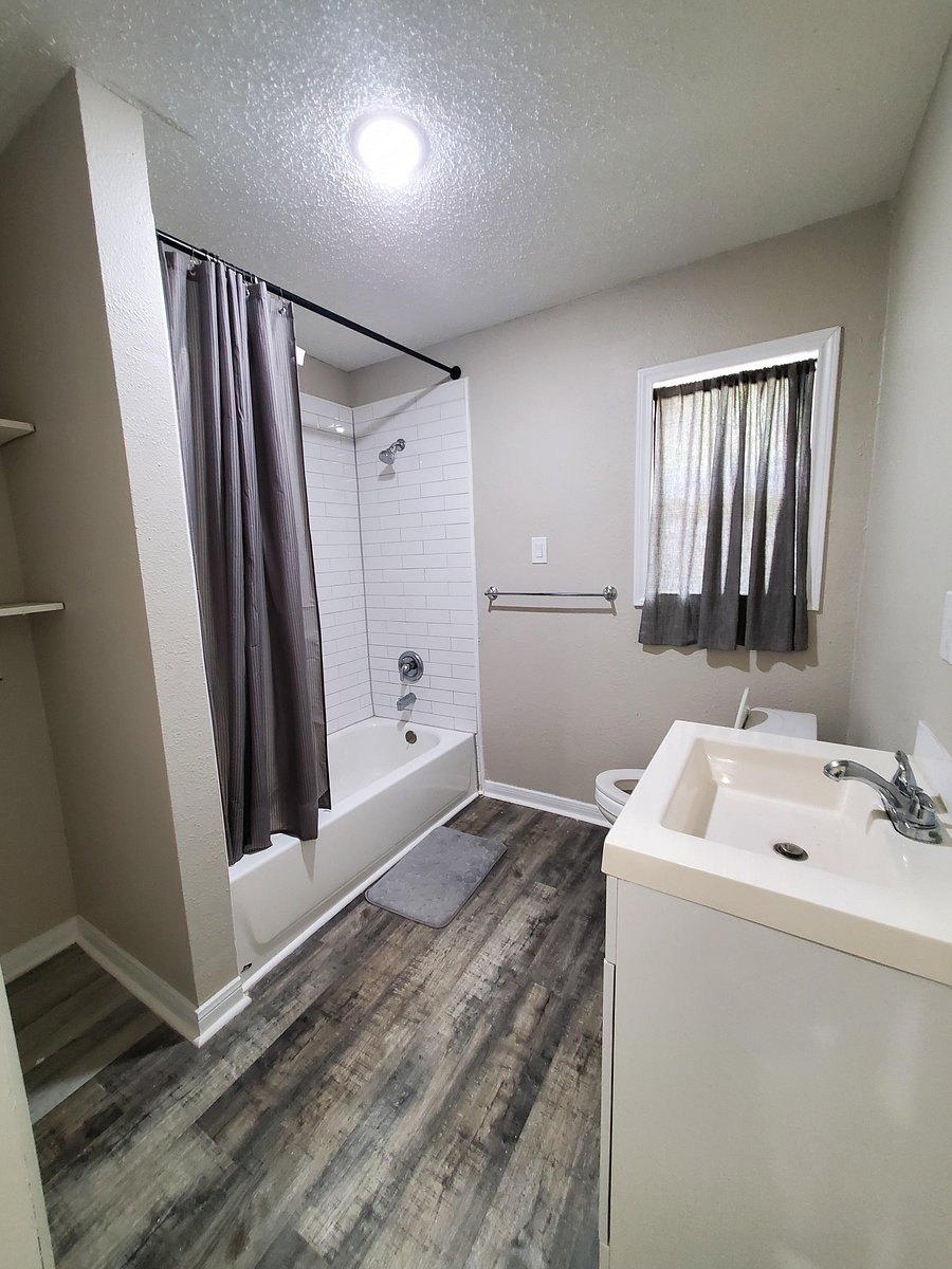 Modern full bathroom featuring a sleek vanity and updated flooring