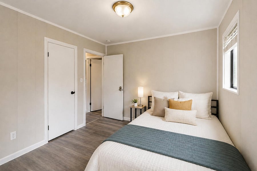 Comfortable bedroom with wood-look flooring, a large window, and convenient closet access for everyday storage.