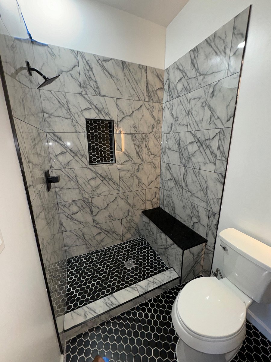 hexagon tile on the floor and niche of the bathroom w/ quartz seated bench