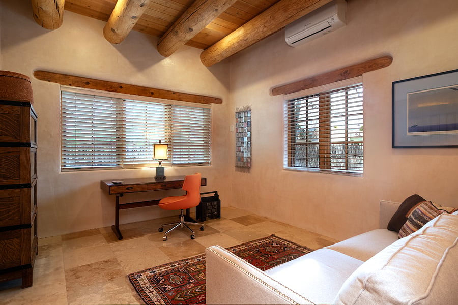 Office with desk, bookcase, sofa, storage closet and router.