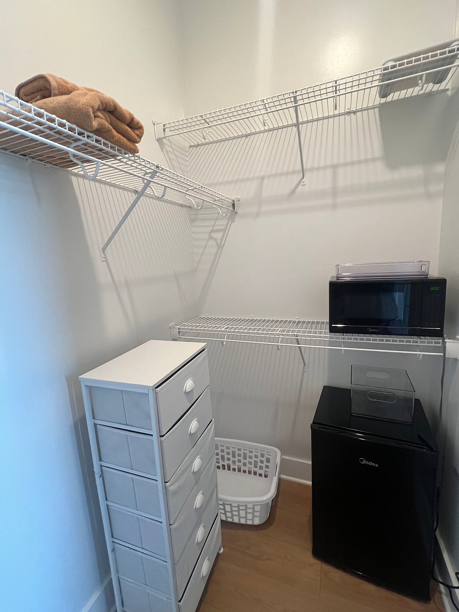 Spacious walk-in closet with mini fridge and microwave.