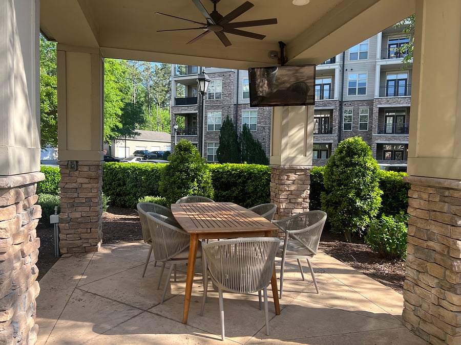 Outdoor covered seating with fans and tv near bbq area