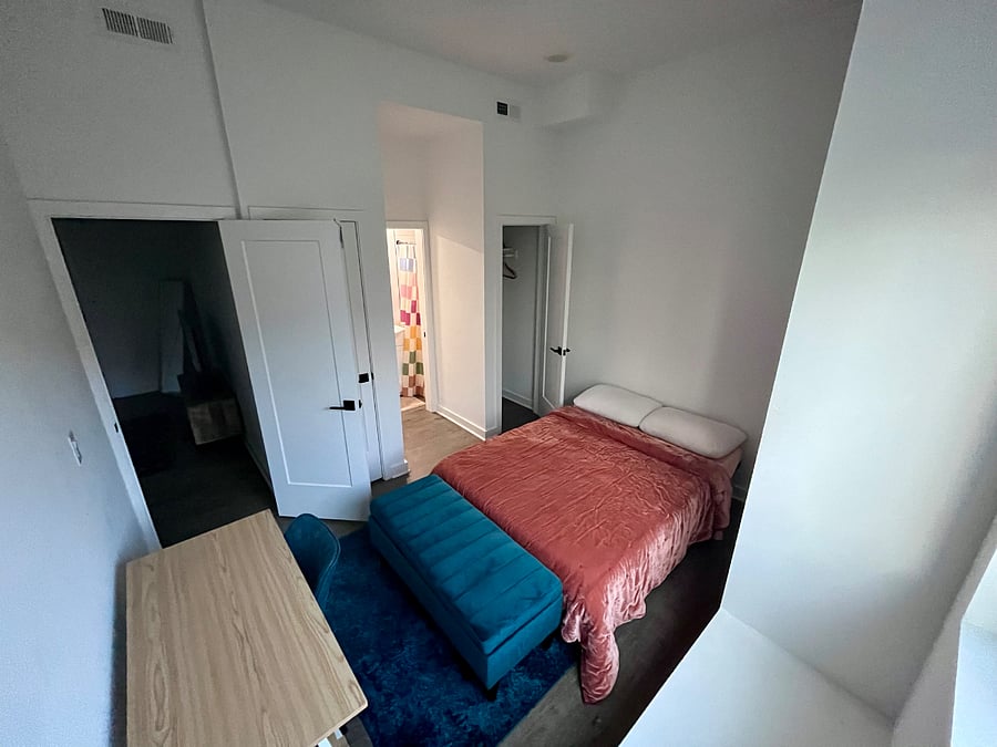 Bedroom 2 has a full size bed, closet, and desk. There is a full bath with a toilet and standing shower.