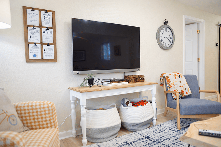 Inviting living space with wall-mounted smart TV, stylish dcor, and cozy seating for movie nights or downtime.