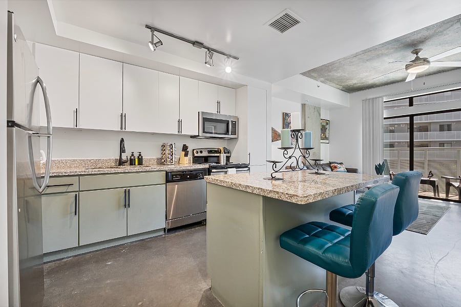 The modern kitchen features a spacious kitchen island with sleek seating, providing the perfect spot for casual dining or morning coffee. Fully equipped with high-end appliances and ample counter space, its a functional and stylish hub for all your culinary needs.
