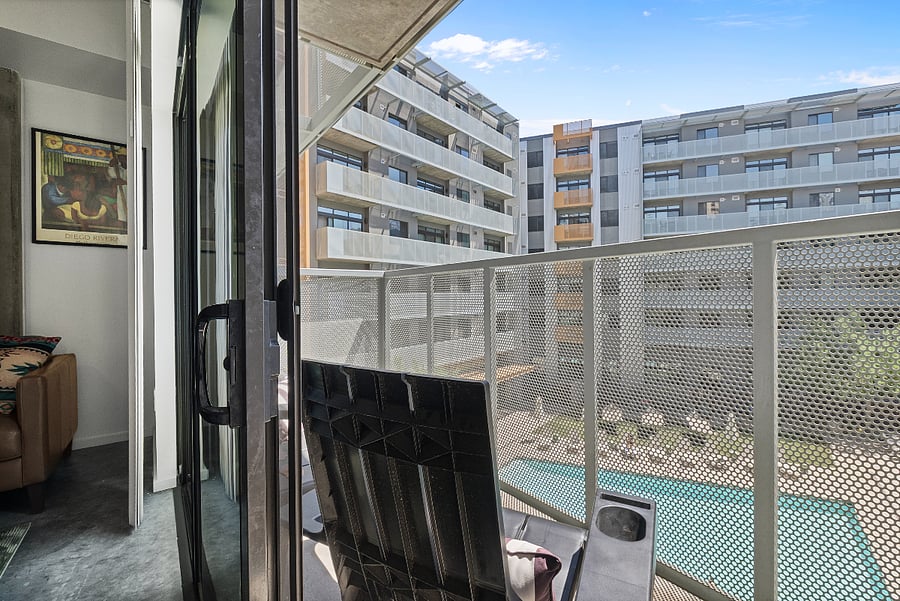 Step out onto your private balcony and enjoy a refreshing view of the sparkling swimming pool. This elevated outdoor space is the perfect spot for your morning coffee or a quiet evening breeze, overlooking the resort-style amenities below.