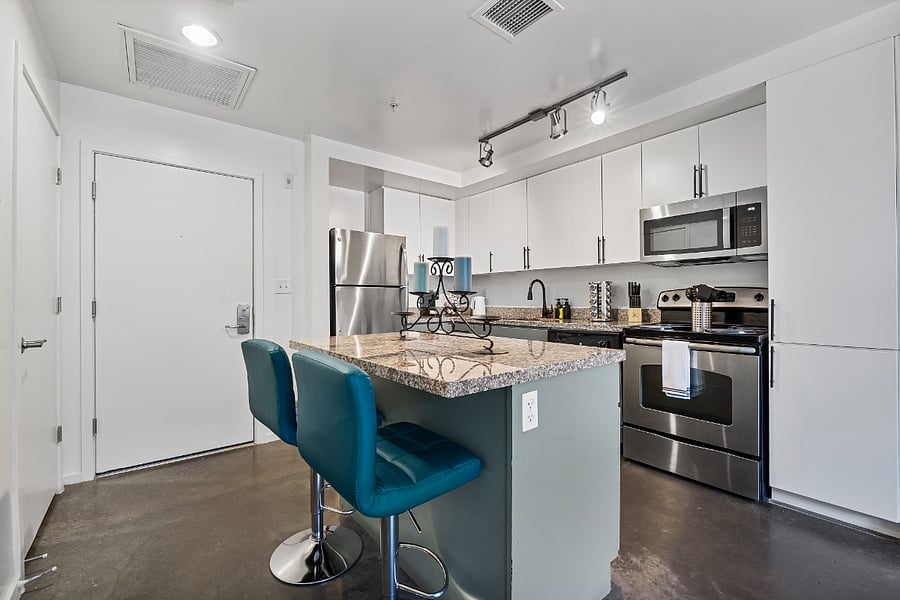 The modern kitchen features a versatile kitchen island with sleek seating, serving as the perfect multi-purpose hub for casual dining or a dedicated work-from-home space. Fully equipped with high-end appliances and ample counter space, its designed to handle everything from gourmet meal prep to your morning emails.