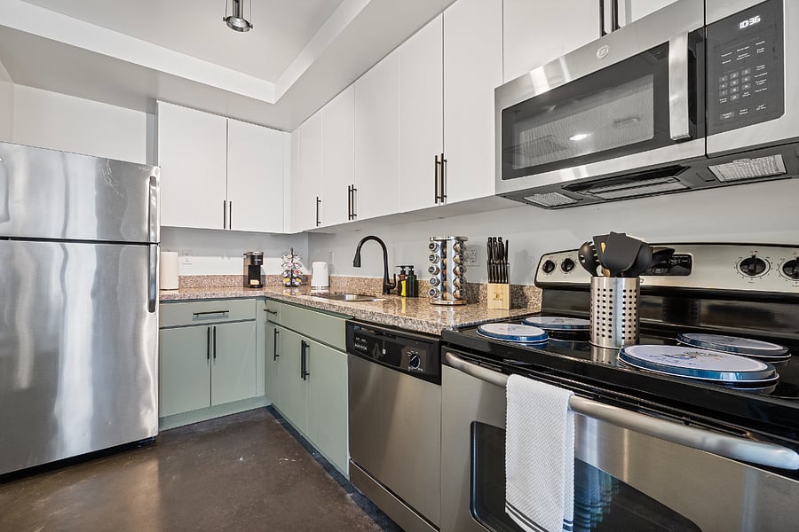 Modern, fully equipped kitchen featuring a full-sized refrigerator, stove, oven, microwave, and dishwasherperfect for home-cooked meals.
