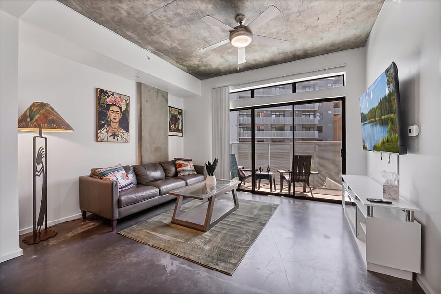 The light-filled living room offers a perfect blend of indoor-outdoor living, featuring a plush, full-sized couch and direct access to your own private balcony. Its an ideal spot to relax, enjoy the fresh air, or unwind after a busy day in the city.