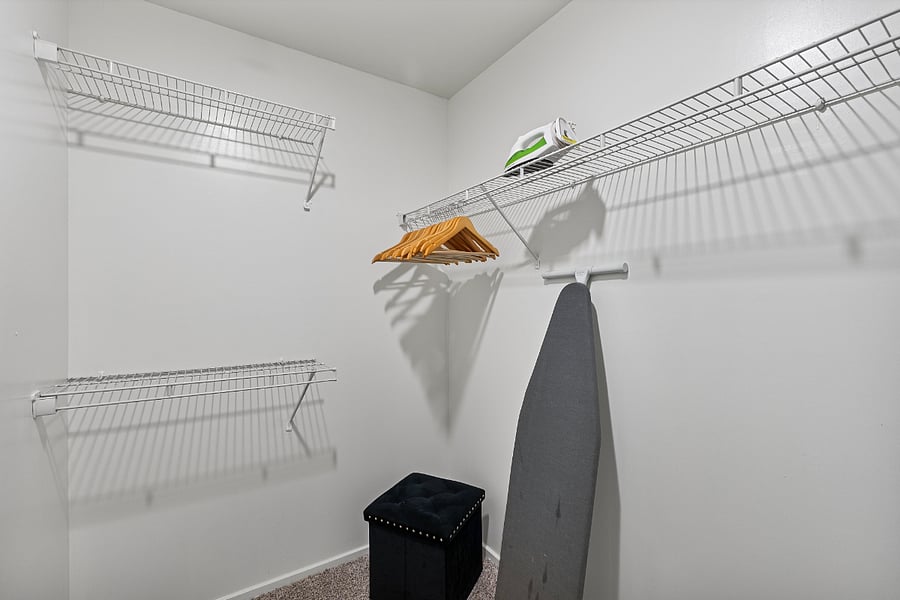 Spacious walk-in closet featuring ample storage and a full-sized ironing board and ironkeeping your wardrobe crisp and ready for the day.