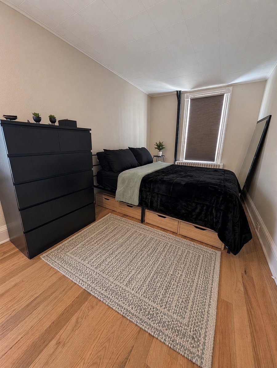 Comfortable main bedroom w/ dresser, full size floor mirror, blackout shades, side tables, and large closet