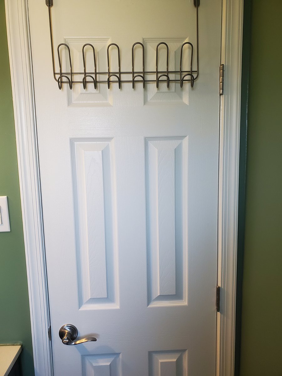 Primary bedroom half bath door with garment hooks.