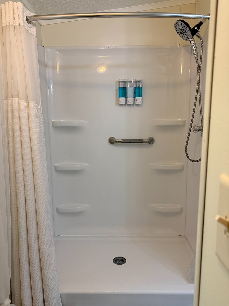 The master bathroom has a walk-in shower and handrails. A shower chair is available upon request. Shampoo, conditioner, and body wash are on the shower wall.