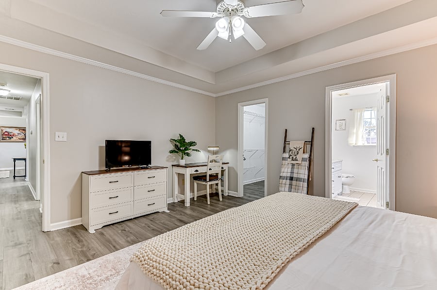 Master bedroom with king size bed, dresser, working desk, tv with Roku stream, and walk in closet.