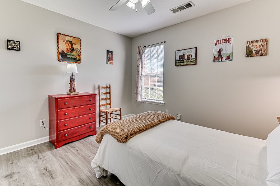 Second bedroom with twin size bed, dresser, and closet.