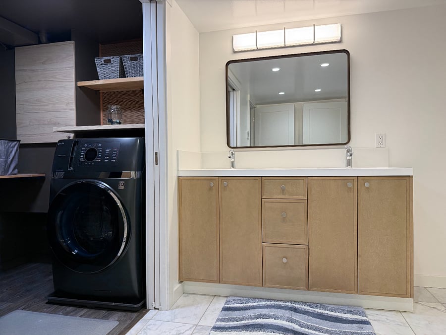 Dual-sink vanity. Direct access to the private laundry room from the bathroom.