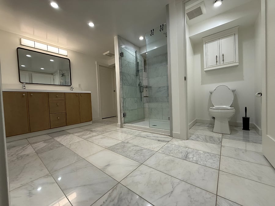 Spacious bathroom (10' x 9') with heated floors, a double vanity, an enclosed toilet, and a closet.