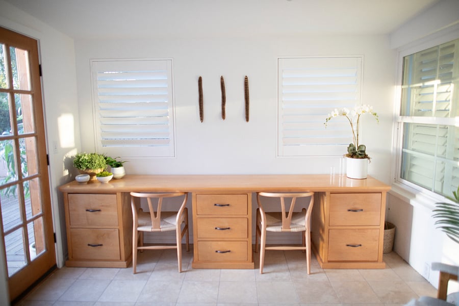 Workstation detail showing custom millwork, French doors, and abundant natural light.