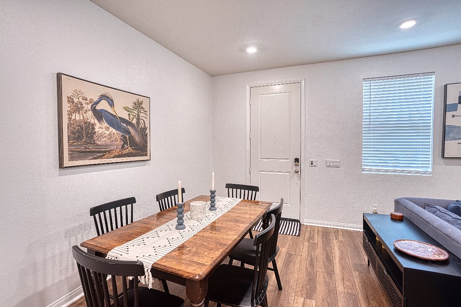Gather around this charming dining table for a family dinner or a board game night. The open layout seamlessly connects the dining and living spaces, creating a warm, inviting atmosphere for your Santa Clarita stay.