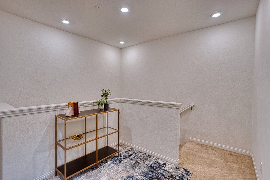 A stylish landing area connects the living spaces. This thoughtful transition point leads to the private upstairs bedrooms, featuring modern decor and a clean, airy feel that carries throughout the entire townhome.