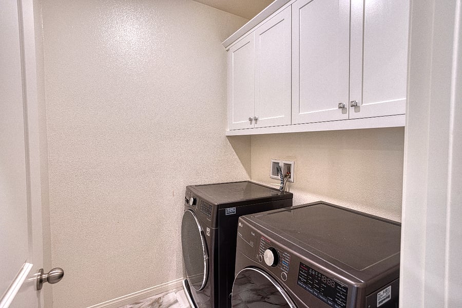A clean and bright laundry room equipped with a high-capacity washer and dryer. Located conveniently within the home, this space ensures you have everything needed to keep things fresh and easy during your Santa Clarita stay.
