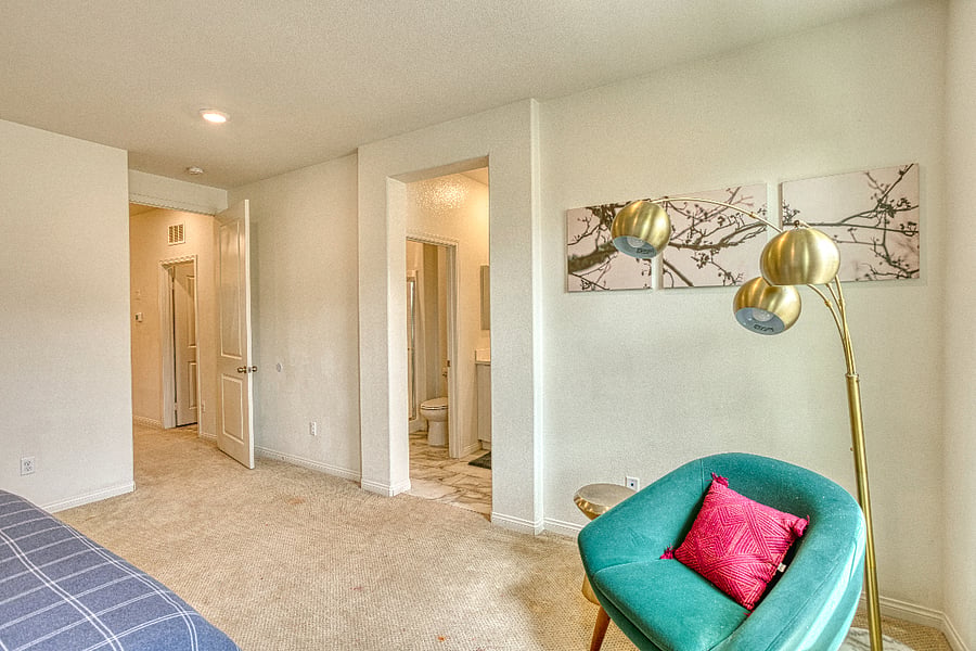 A bright and spacious layout in the primary suite. This view highlights the seamless flow from the bedroom to the private en-suite bathroom, featuring modern accents and a cozy seating area for a truly relaxing stay.