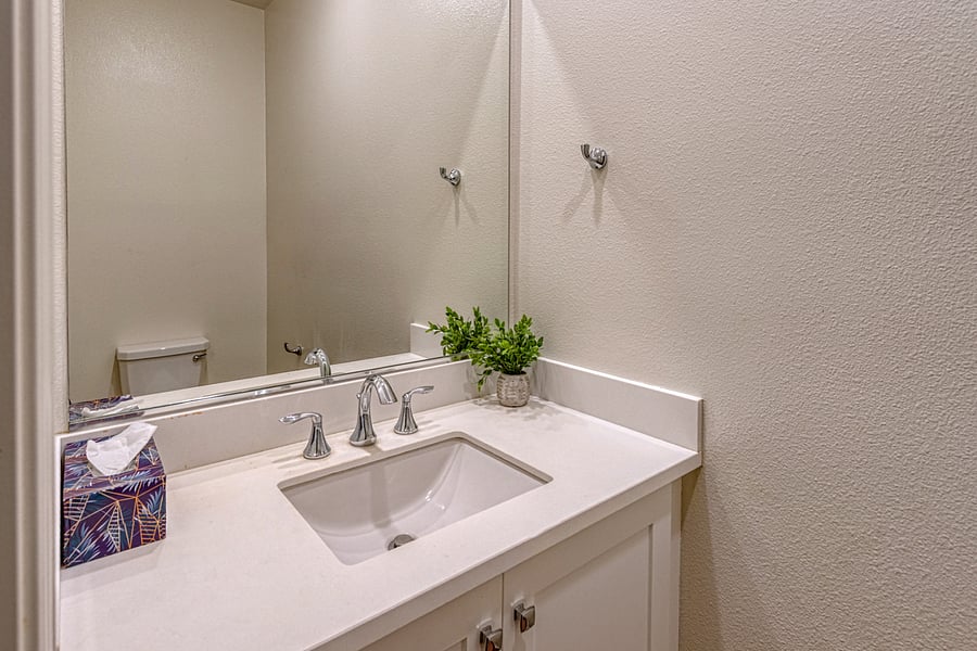 A clean and convenient first-floor powder room featuring a modern vanity, spacious mirror, and bright lighting. Perfectly situated for guests and easy access from the main living areas. Ideal for both mid-term stays and corporate rentals.