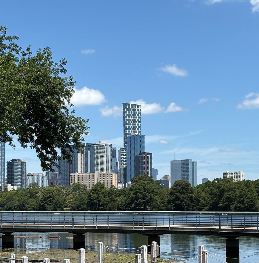 A view from the Waterfront's back lawn, looking out to the boardwalk trail over Ladybird Lake and across the water to downtown Austin.