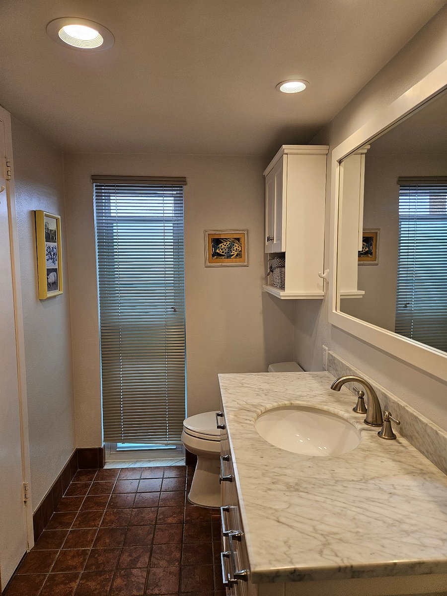 Bath with walk in shower is private to larger bedroom.