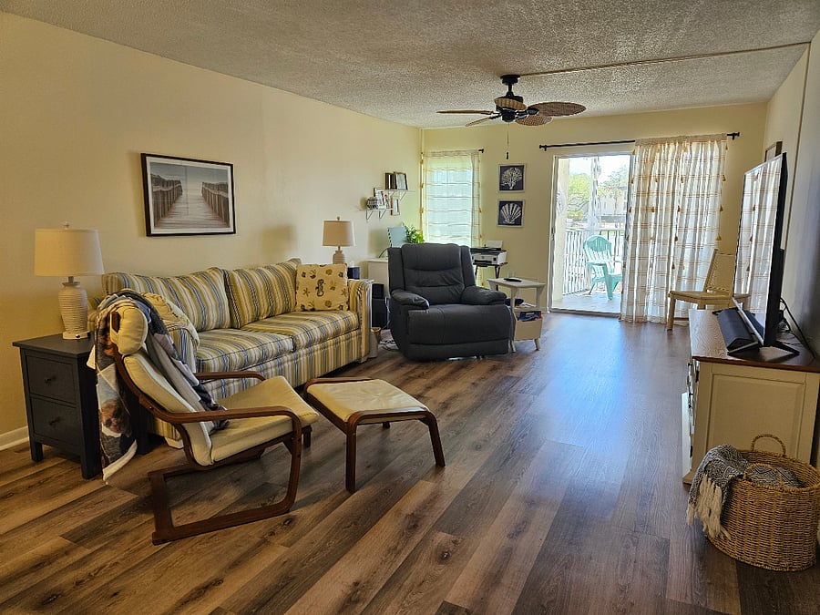 Living room is light and airy. Has desk, TV, 2 bar stools at counter and is attached to the lanai.