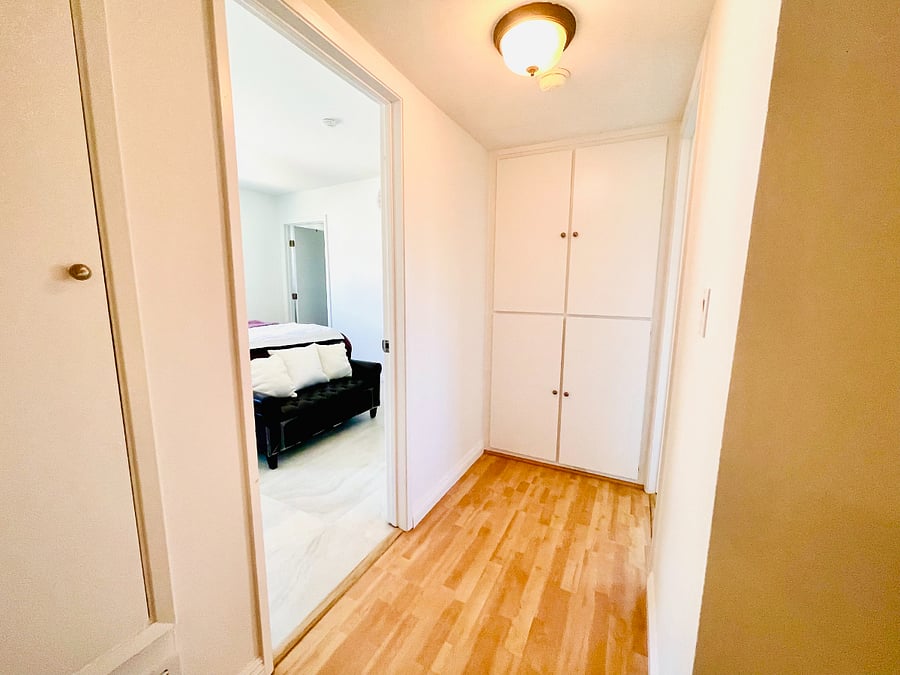 Hallway between bedrooms with storage space.