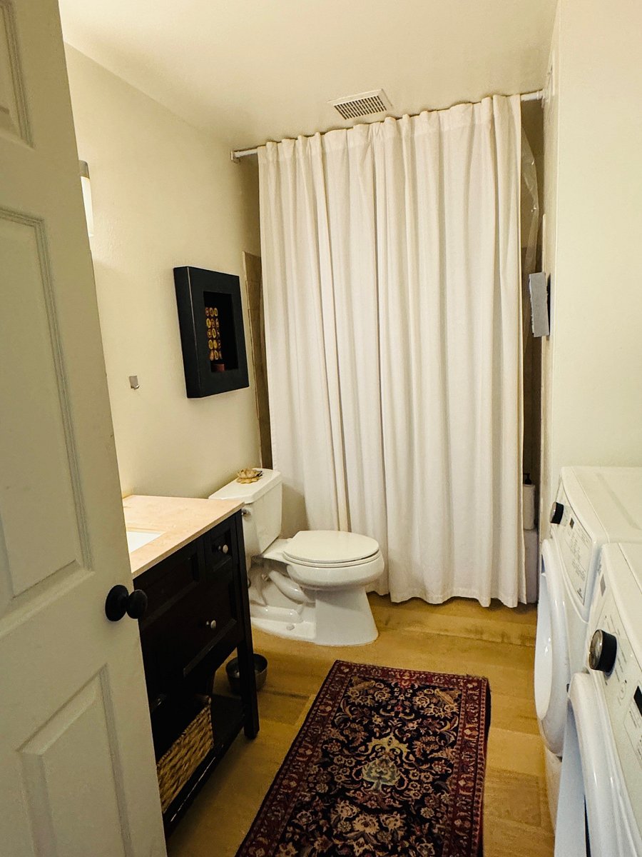 Hall bathroom with tub and shower plus washer/dryer